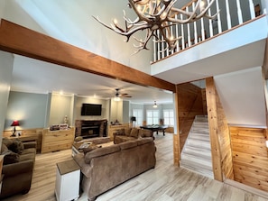 Ein geräumiges Wohnzimmer mit Kamin, Billardtisch und einer Treppe zu einer oberen Etage.