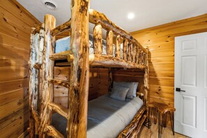 Un lit superposé avec une structure en bois, un matelas et des oreillers.