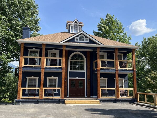 A two-story building with a central entrance, large windows, and a balcony.