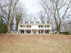 A two-story building with a central entrance, multiple windows, and a balcony on the upper floor.