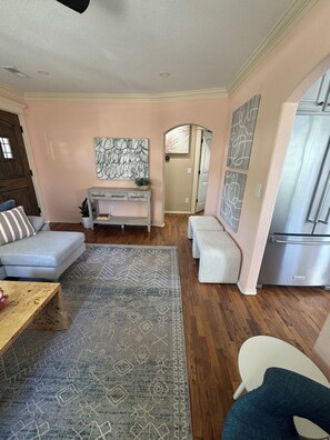 A living room with a sofa, a coffee table, a rug, a console table, and artwork on the walls. - The Pink B • Walk to Square •Airship•Crystal Bridges • MTB Trails (Bentonville)