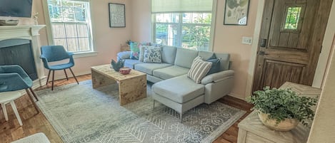 A living room with a sofa, a coffee table, a TV, and a ceiling fan.