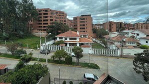 Un quartiere residenziale con diversi condomini, un ingresso con cancello e una strada con auto parcheggiate.