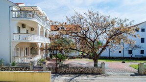 A two-story building with balconies, a stone wall, and a tree in the courtyard. - Sea Side Moretti Near Vodice & Beach (Vodice)