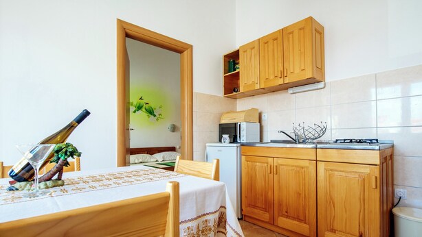 A small kitchen with wooden cabinets, a microwave, and a sink. - Sea Side Moretti Near Vodice & Beach (Vodice)