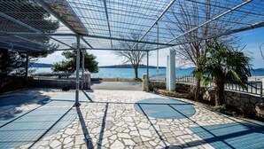 A covered outdoor area with a stone floor, metal railing, and a view of the sea. - Sea Side Moretti Near Vodice & Beach (Vodice)