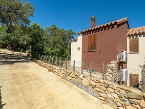Un bâtiment avec un mur en pierre, une porte en bois et une fenêtre.