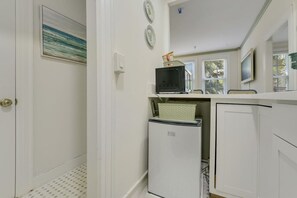 A compact kitchen with a refrigerator, microwave, and a small cabinet. - The Atelier on the Island - Steps to Beach (Palm Beach)