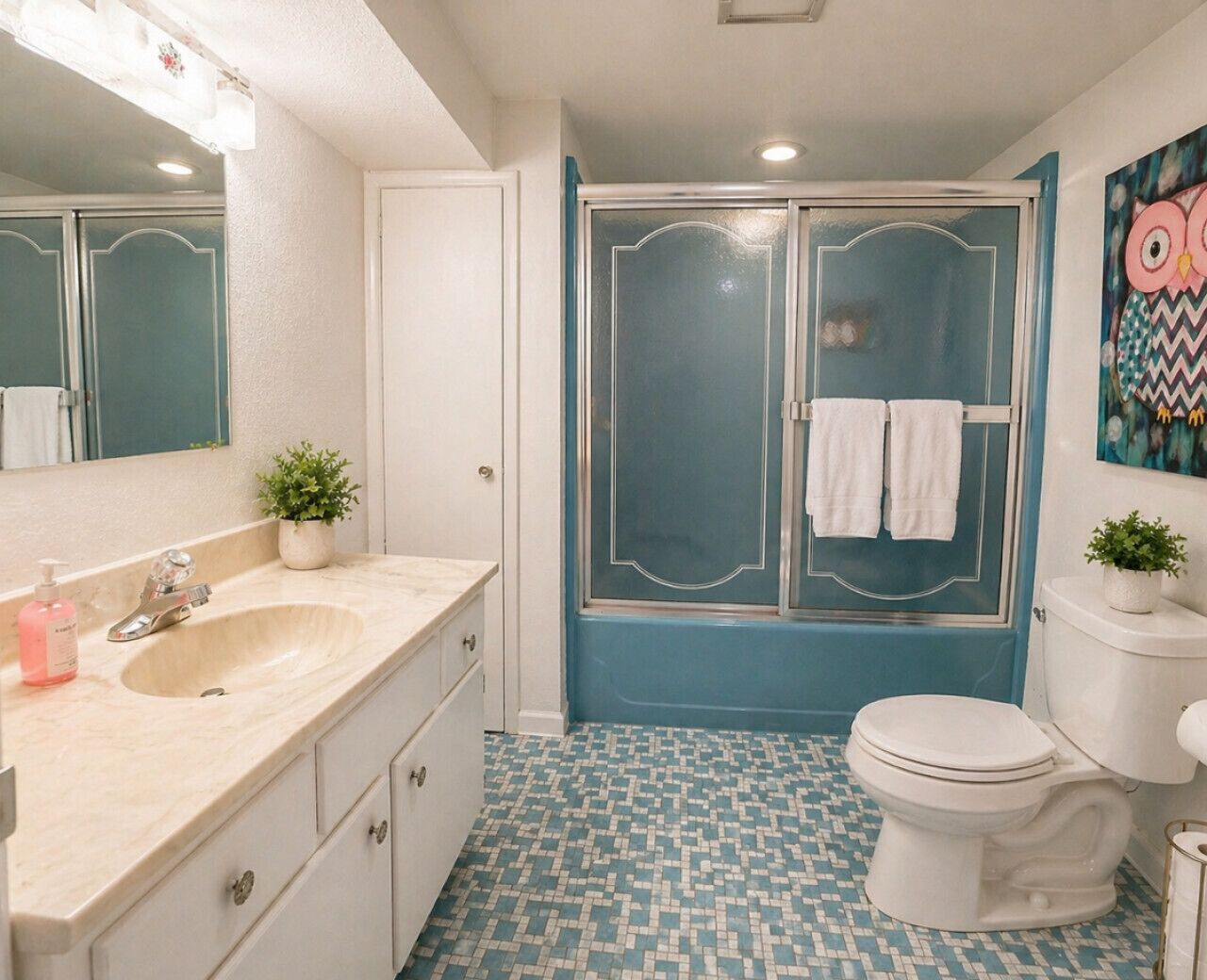 Un baño con lavamanos, espejo, inodoro y ducha.
