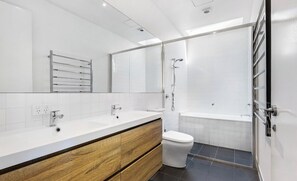 A modern bathroom with a large mirror, a wooden vanity, a toilet, and a shower area. - Large Bedroom with Courtyard Near St Kilda Beach (St Kilda)