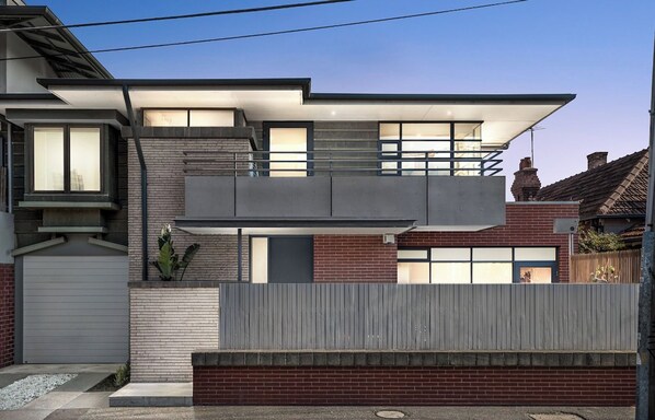 A modern two-story house with a flat roof, large windows, and a garage. - Large Bedroom with Courtyard Near St Kilda Beach (St Kilda)