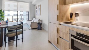Una cocina moderna con armarios de madera, horno integrado y un reloj digital que muestra las 10:50.