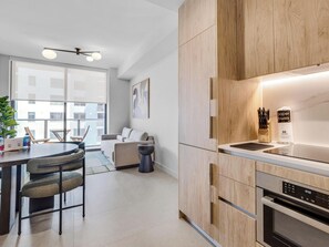 Eine moderne Küche mit Holzausbau, einem eingebauten Backofen und einer digitalen Uhr, die 10:50 Uhr anzeigt.