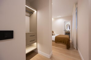 Ein Schlafzimmer mit Bett, Nachttisch und begehbarem Kleiderschrank mit Schubladen.