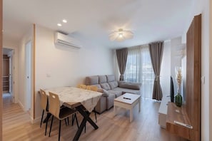 Ein modernes Wohnzimmer mit Esstisch, Sofa und kleinem Couchtisch.