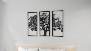 Eine Wand mit drei gerahmten Schwarzschnitten von Bäumen.