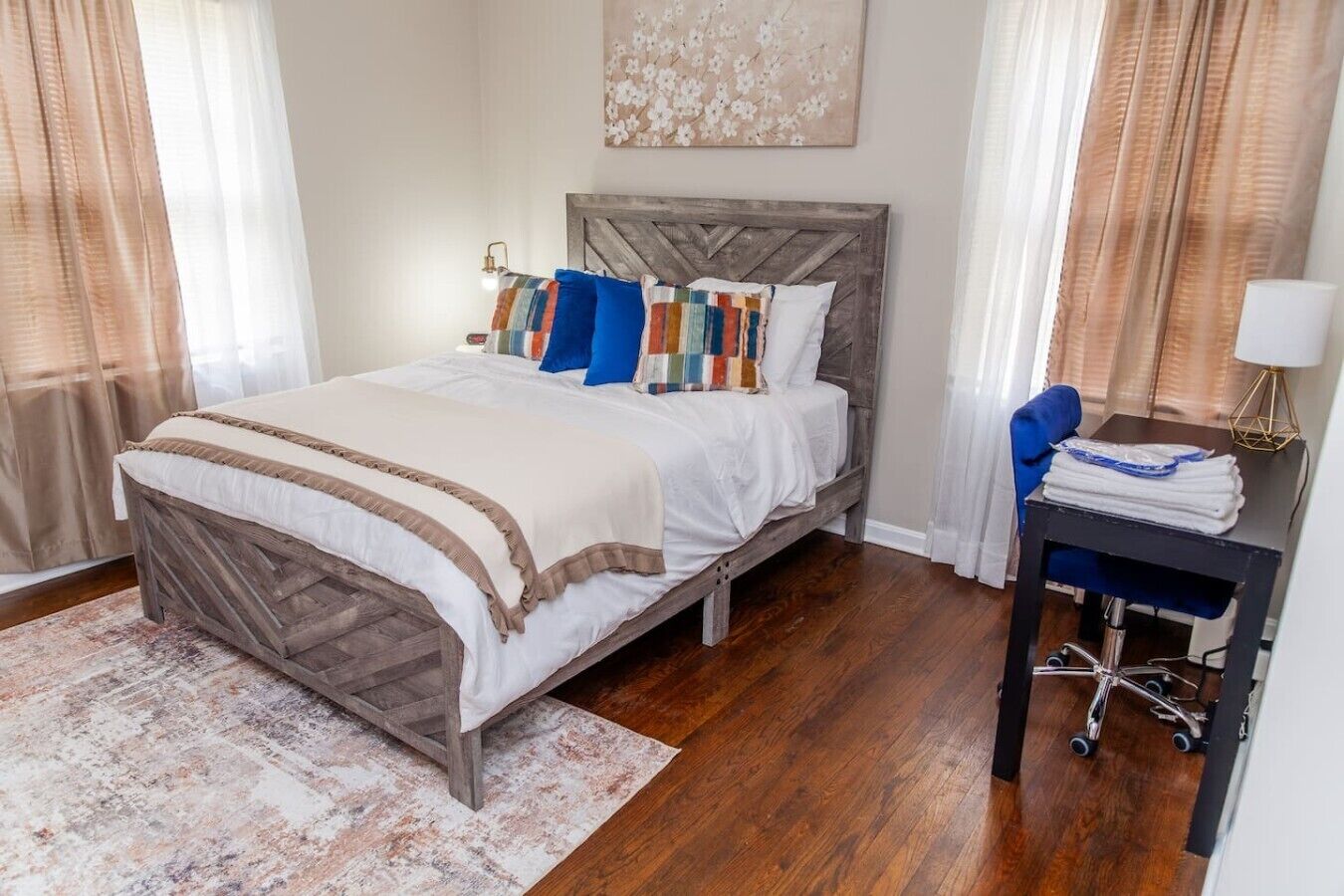 Une chambre à coucher avec un lit, un bureau, une chaise et une lampe.