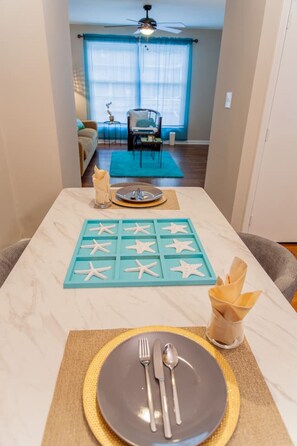 A dining table set with a plate, cutlery, a glass, and starfish-shaped molds. - Cozy Inside, All Things Outside (Decatur)