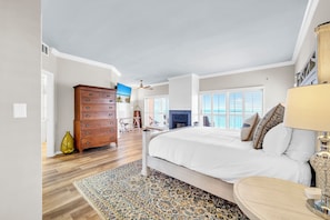 Ein Schlafzimmer mit Bett, Kommode und Blick ins Freie.