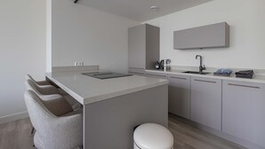 A modern kitchen with a central island, built-in appliances, and a minimalist design. - Modern 3BR Apartment in Rotterdam Centre (Rotterdam)