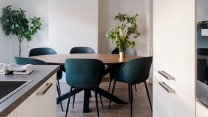 Eine moderne Küche mit einem Holztisch, stuhlfarbenen Sesseln und Blumentöpfen.