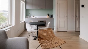 A modern kitchen with white cabinets, a dining table, and chairs. - Cosy City Apartment in Rotterdam West (Rotterdam)