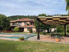 A two-story house with a balcony, a covered patio area with outdoor furniture, and a swimming pool. - Farmhouse - Villa Montesegnale (Bolsena)