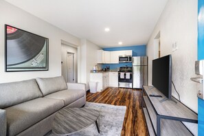 A modern living room with a sofa, a coffee table, and a flat-screen TV.
