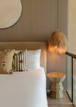 A bed with white bedding, a woven side table, and a textured wall. - Nuup Pomona Romantic Jungle Loft Beach Club Access (Tulum)