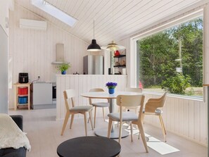 Eine moderne Küche mit Einbauherd, Kühlschrank und Blick auf Grünflächen.