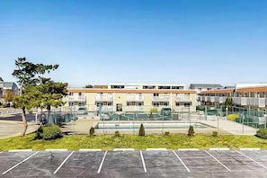 A multi-story building with a parking lot in front.