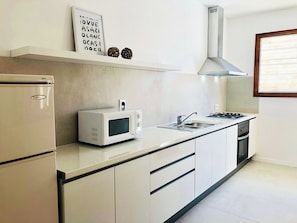A modern kitchen with a built-in microwave, stove, and oven.