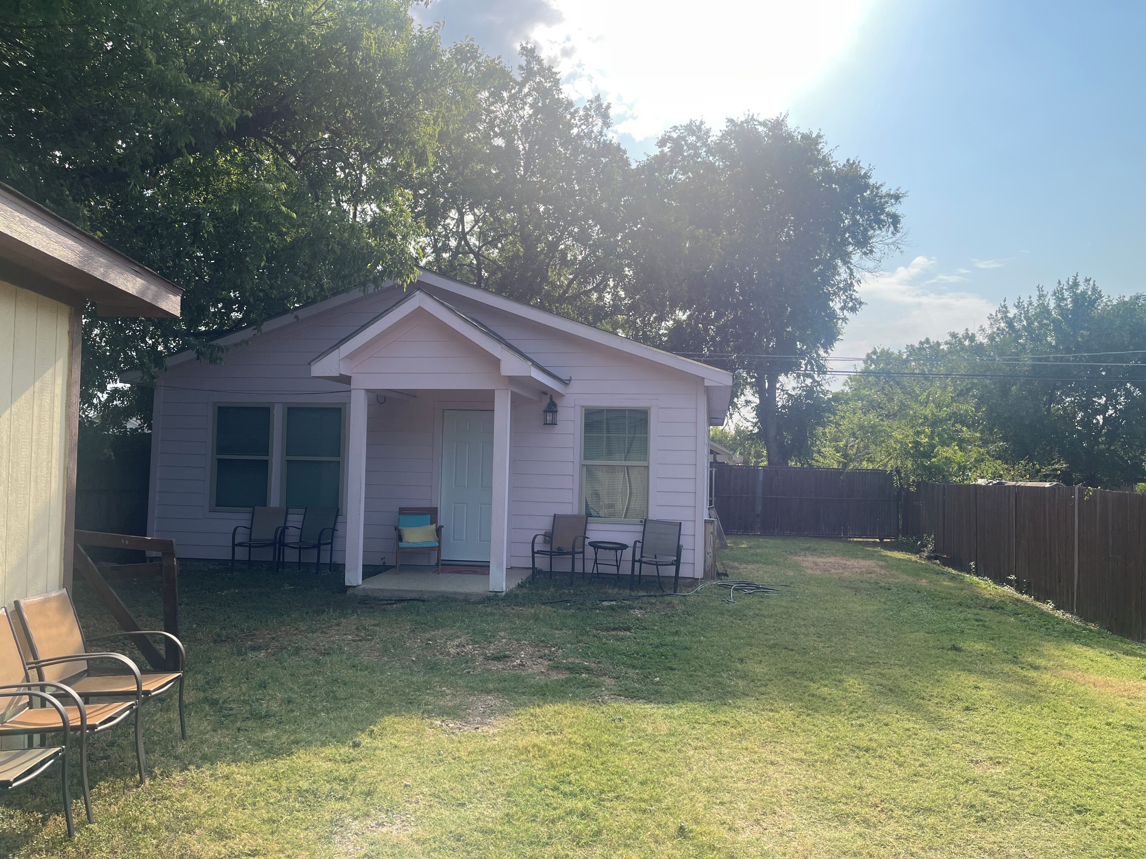 A small single-story house with a porch, two windows, and a door.