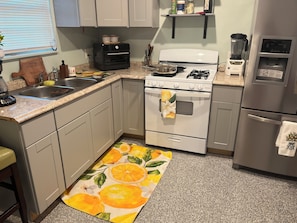 A kitchen with a stove, oven, sink, and a countertop with a blender. - Casa familiar cerca de Stockyards (Fort Worth)