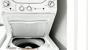 En bild som visar en vit tvättmaskin framifrån, med en kontrollpanel, en lucka och en energimärkning.