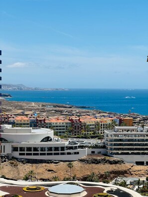 Eine Küstenstadt mit modernen Gebäuden, einem Hafenbecken und Blick auf das Meer.