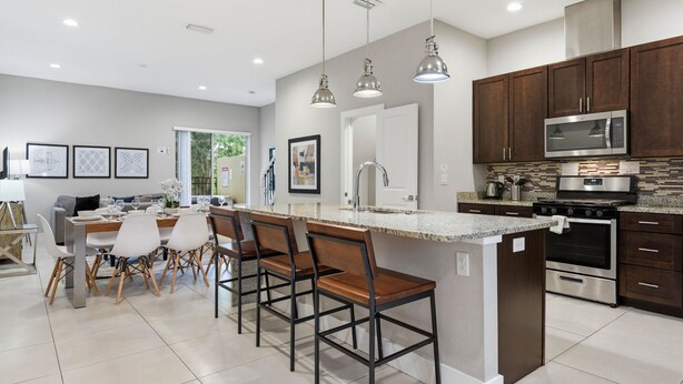 A modern kitchen with a central island, stainless steel appliances, and pendant lighting. - Family Retreat With 4bed Suites & Private Jacuzzi (Kissimmee)
