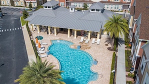 A residential building with a swimming pool, lounge chairs, and palm trees. - Family Retreat With 4bed Suites Private Jacuzzi (Kissimmee)