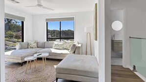 Una sala moderna con un sofá, una mesita redonda y una lámpara de pie.