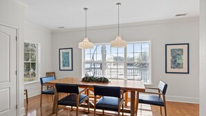 A dining room with a wooden table, six chairs, two pendant lights, and large windows with a view. - 6-BR Waterfront House; Can Rent Boat Too! (Lake Norman of Catawba)