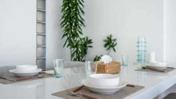 A dining table set with white plates, clear glasses, and a woven placemat. - New1BR Villa Private Pool in Uluwatu (Kuta)