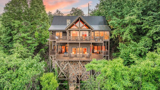 A multi-story log cabin with a balcony, surrounded by dense forest. - Luxury Lodge*Stunning Views*Prime-Location*Arcade (Sevierville)