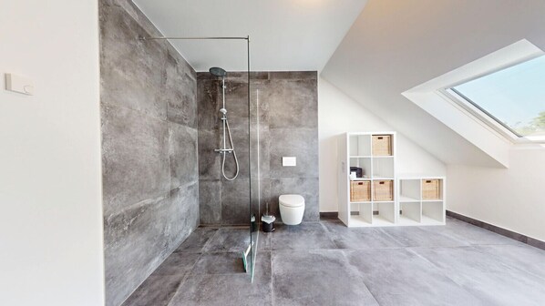 A modern bathroom with a glass-enclosed shower, a white toilet, and a skylight. - Modern, spacious house with 5 bedrooms, 3 bathrooms and a large garden (Kindsbach)