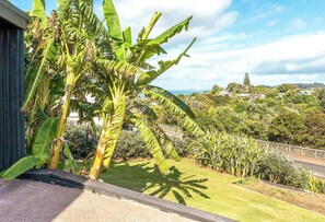 Zona residencial con vistas a un jardín exuberante, un sendero pavimentado y una lejanía de casas y árboles.