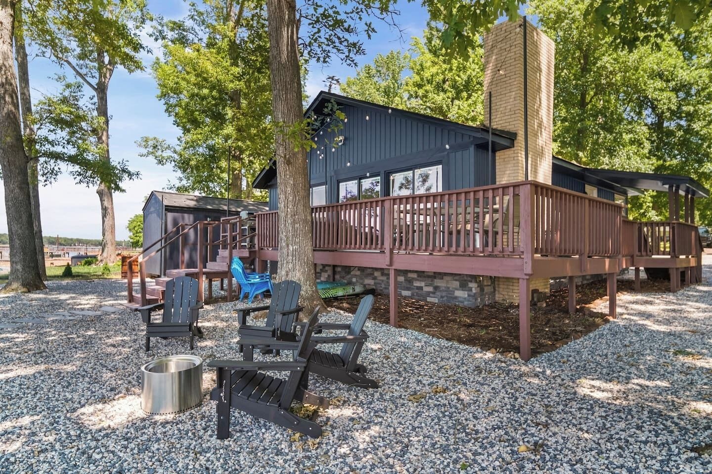 The backyard has many entertaining spaces including dining, lounging, grilling, firepit area, and the dock.
