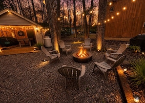 A backyard with a fire pit, outdoor seating, and string lights. - Lake View Lodge/Hot Tub/Game Room/ Grill/Kayak (Lake Harmony)