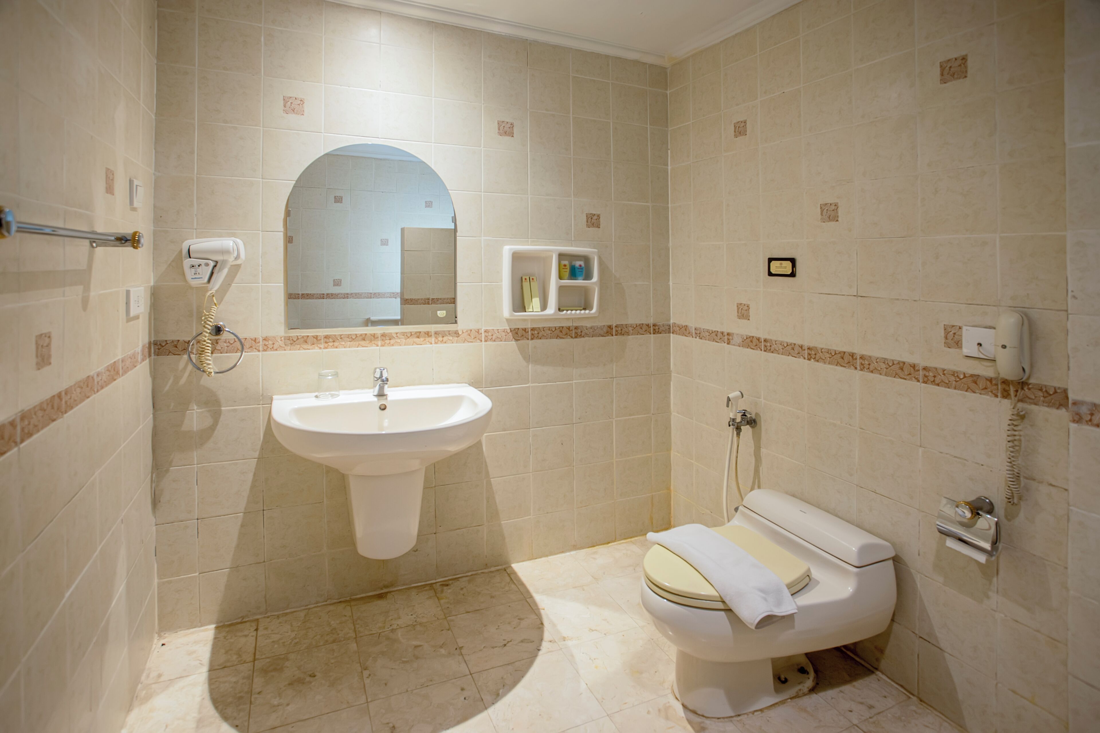 Une salle de bain avec un lavabo, des toilettes et un miroir.