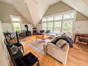 Ein Loft-Wohnzimmer mit Kamin, einer Couch, einem Couchtisch und einer Treppe.