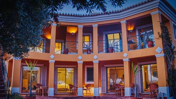 Un hotel de varios pisos con patio, asientos exteriores y una chimenea.