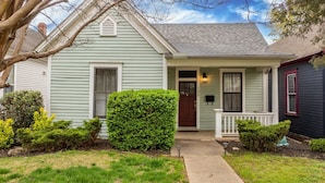 A two-story house with a front porch, a mailbox, and a well-maintained lawn.